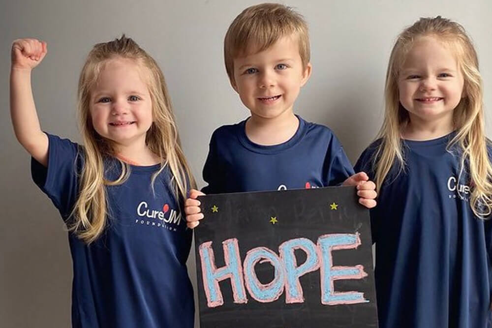 Three little kids holding a sign that says "Hope"